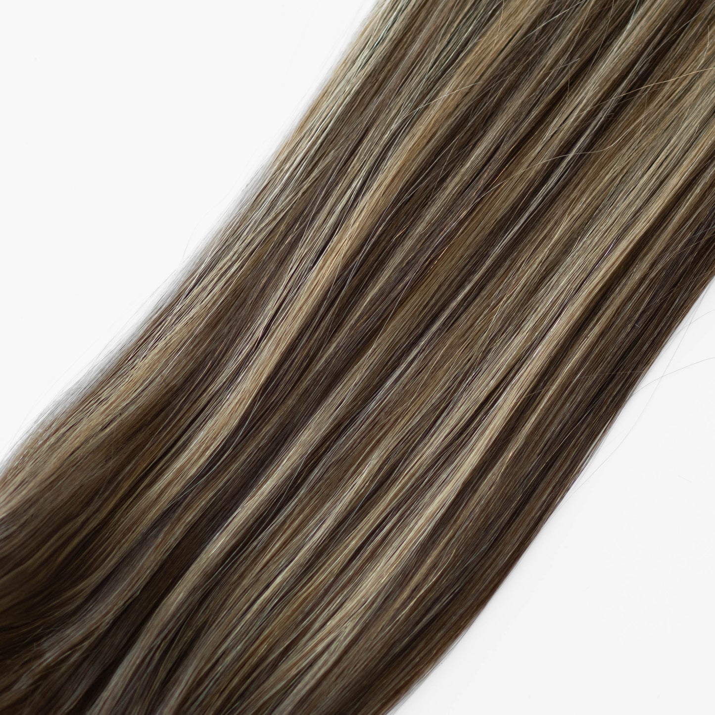 Close-up of brown and blonde hair extensions on a white background