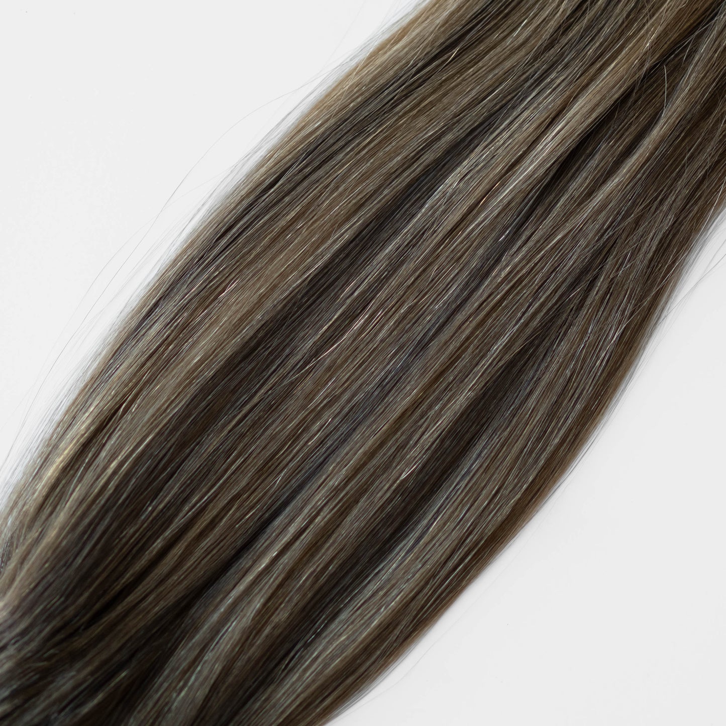 Close-up of brown hair extensions on a white background