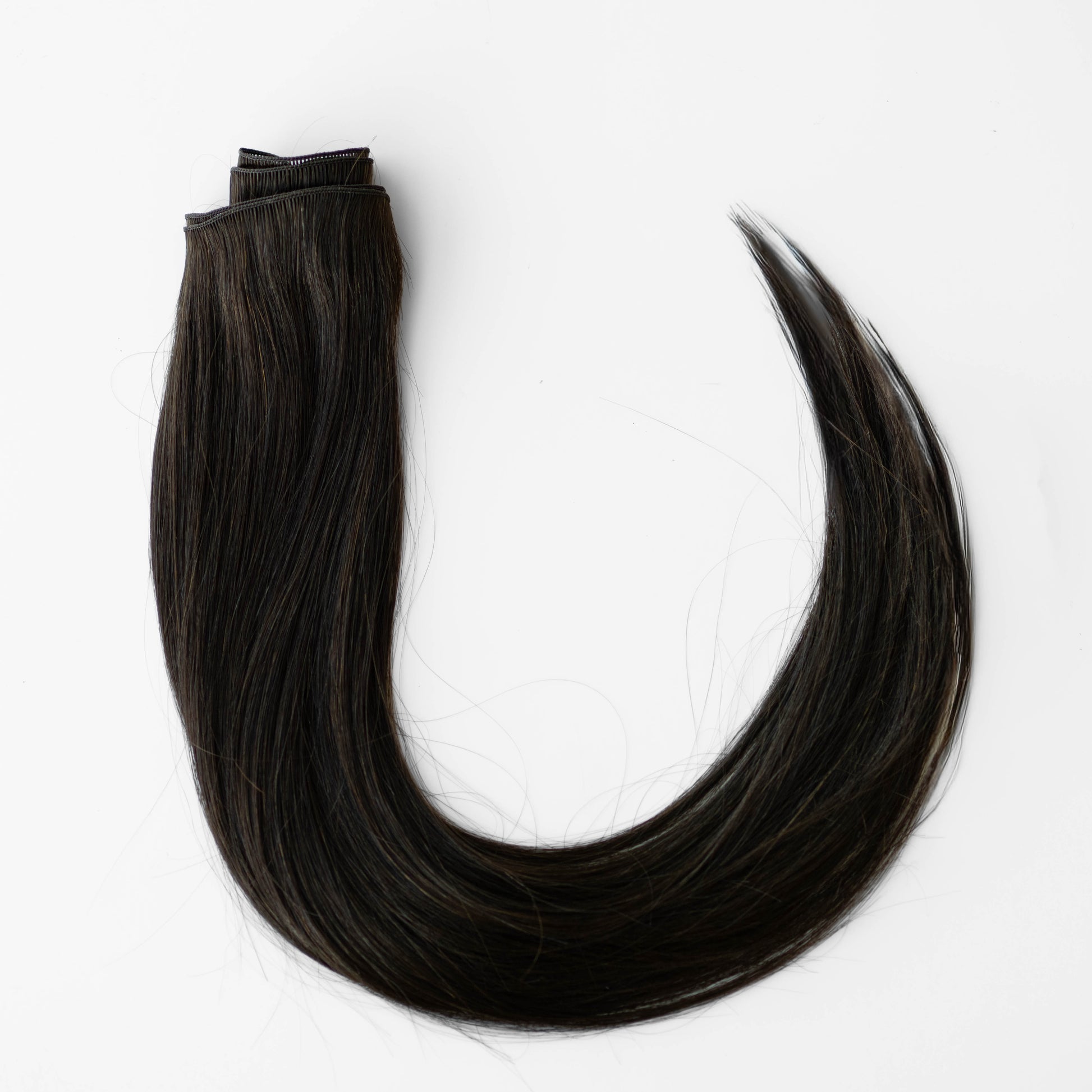 Dark brown hair extensions on a white background