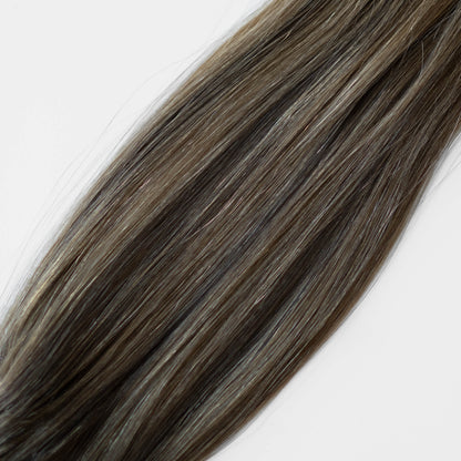 Close-up of brown hair extensions on a white background
