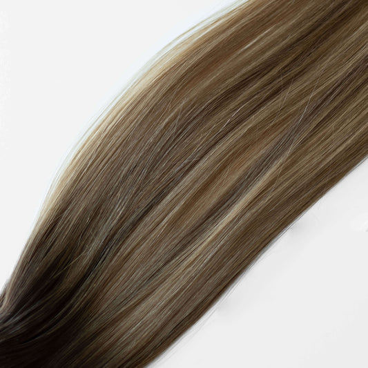 Close-up of brown hair extensions on a white background